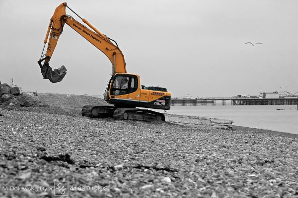 yellow digger on Brighton beach near The Old Pier